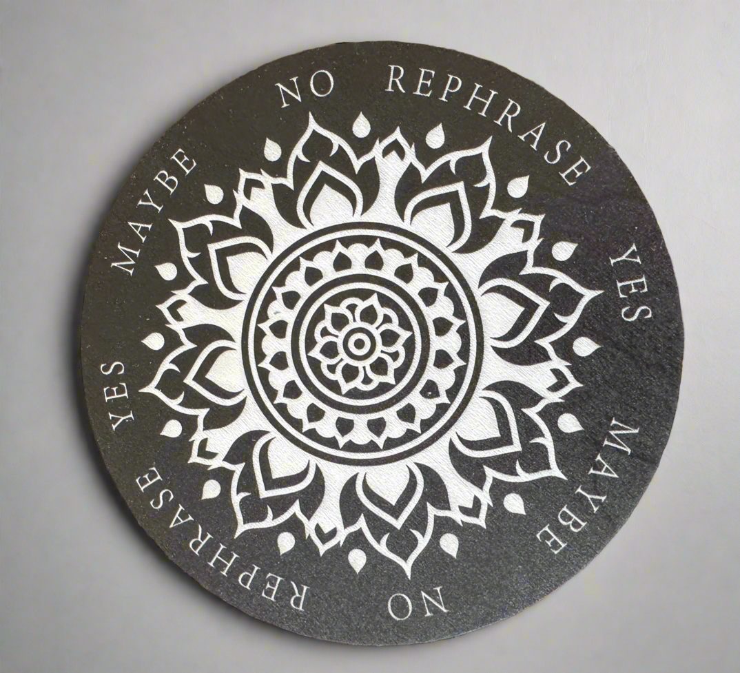 A black and white round divination board with a mandala pattern and the words "Yes," "No," "Maybe," and "Rephrase" printed around the edge.
