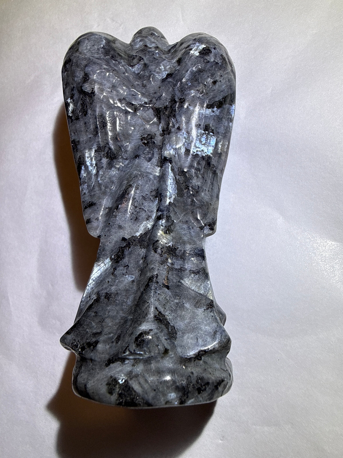 photo of back larvikite crystal detailed hand carved angel with labradorescence light reflection