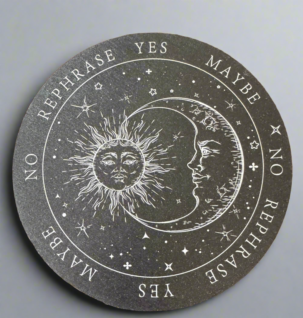 Gray circular disc with white astrological illustrations, including a sun and moon face, stars, and the words "YES," "NO," "MAYBE," and "REPHRASE."
