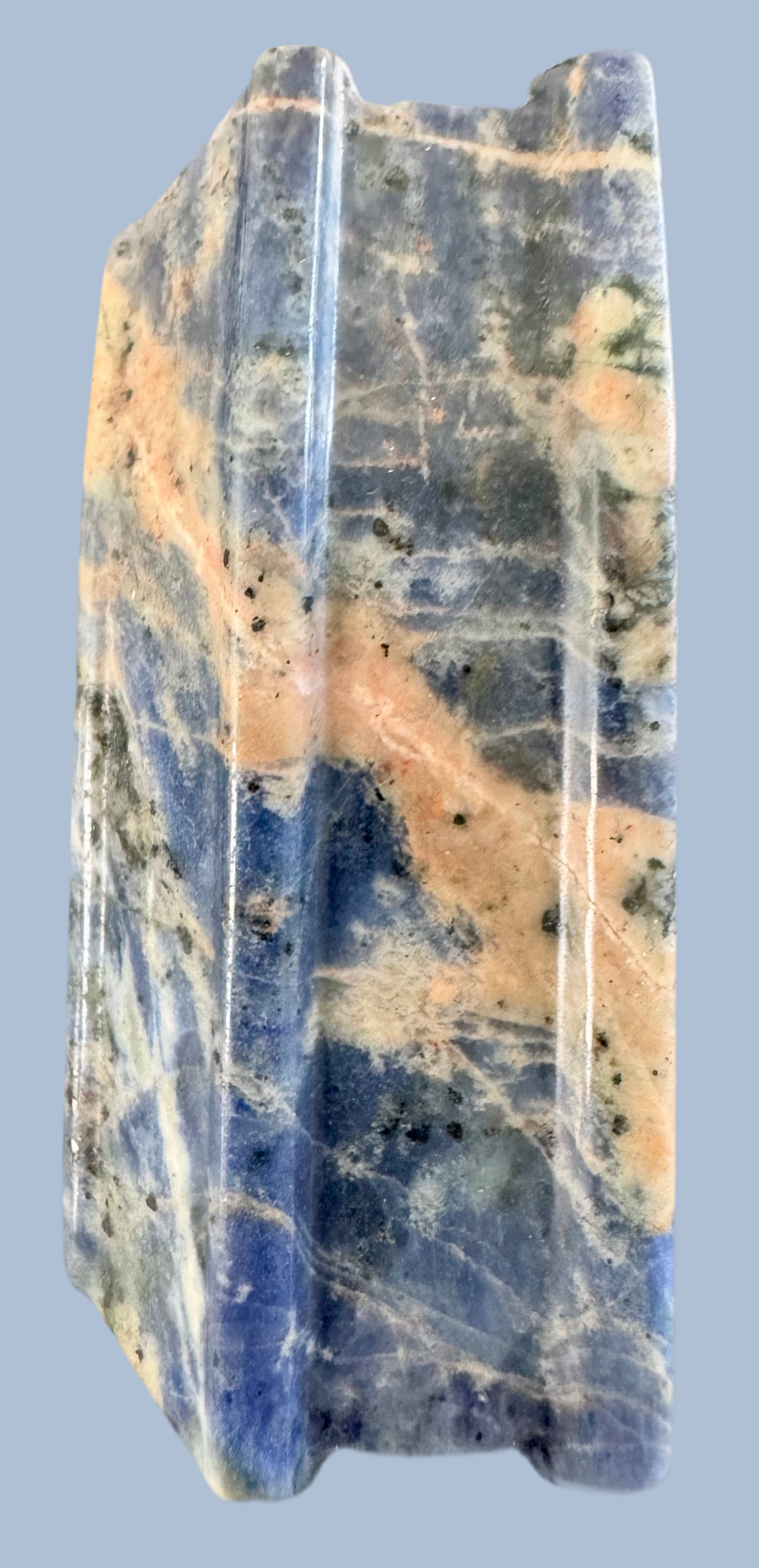Polished blue and peach sodalite stone slab.
