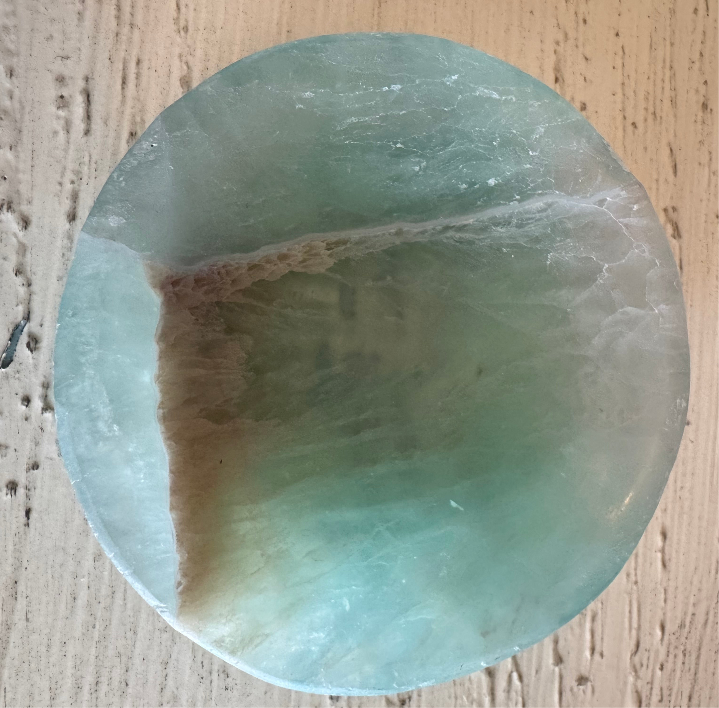 Circular light green and tan gemstone.