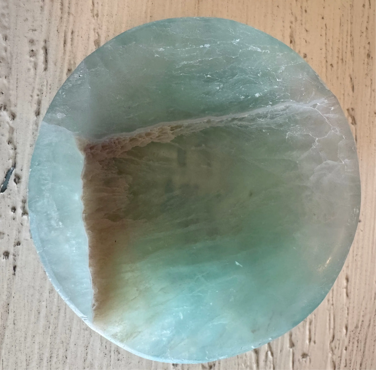 Circular light green and tan gemstone.