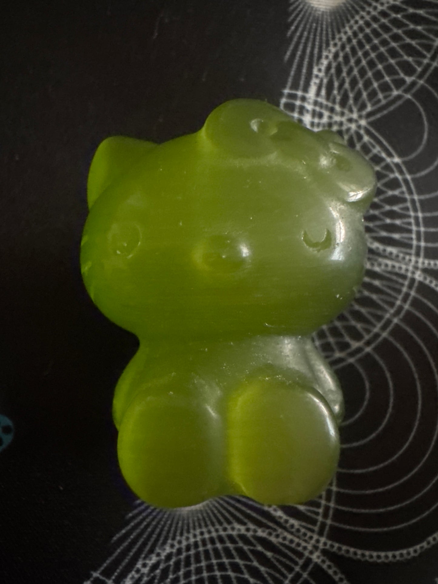 Green gummy Hello Kitty figurine.