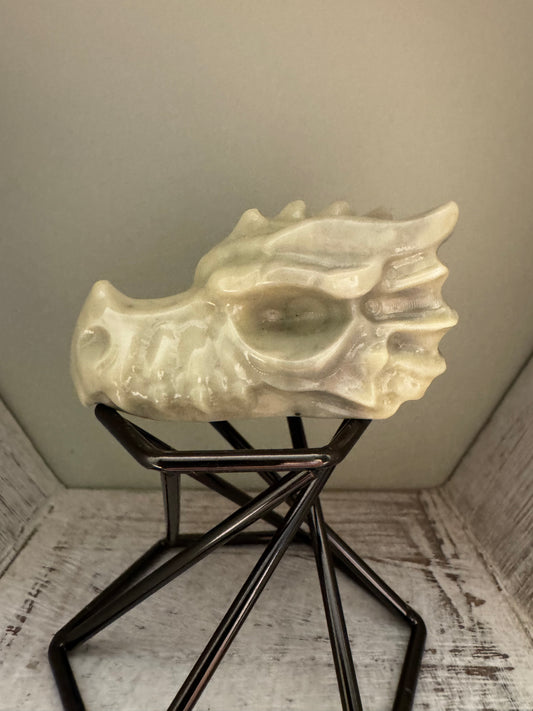 Stone dragon head sculpture on metal stand.