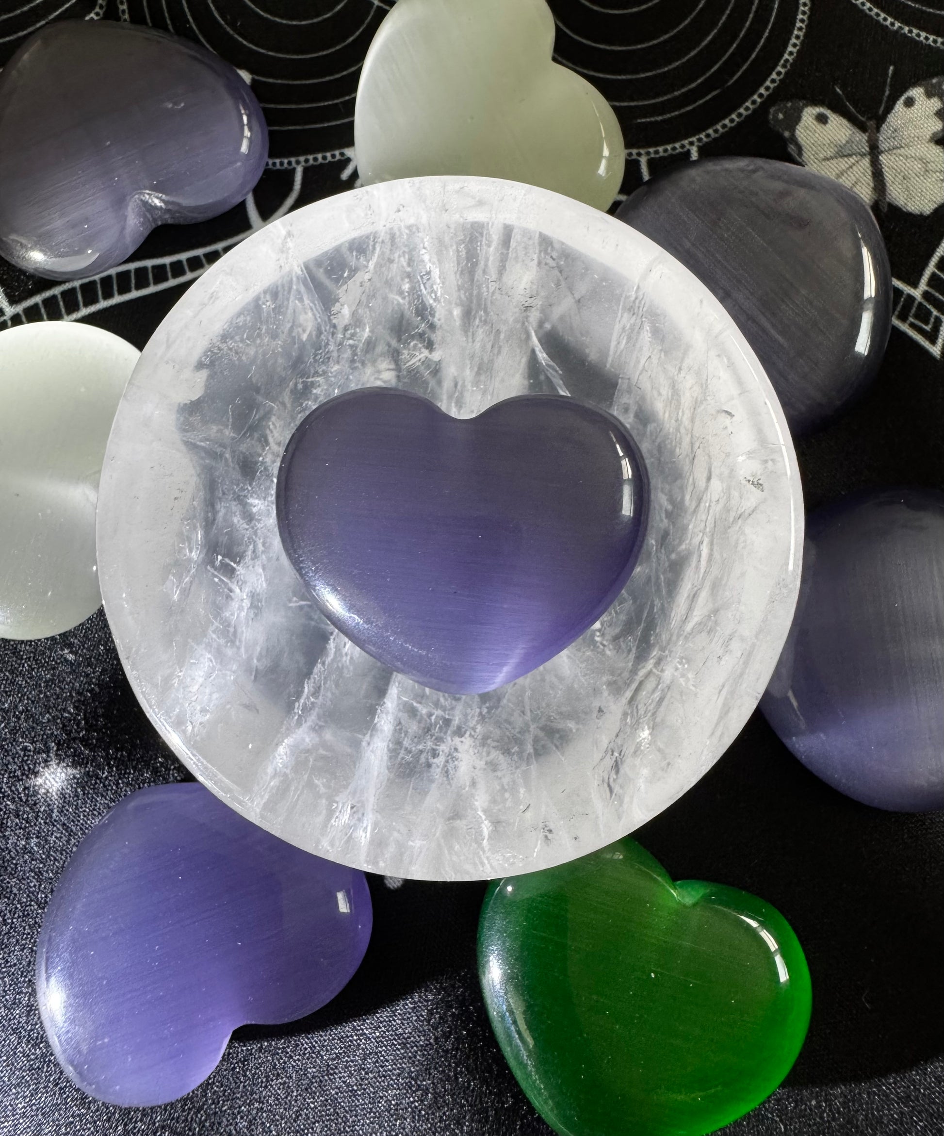 Selenite bowl with purple, green, and white heart-shaped crystals.