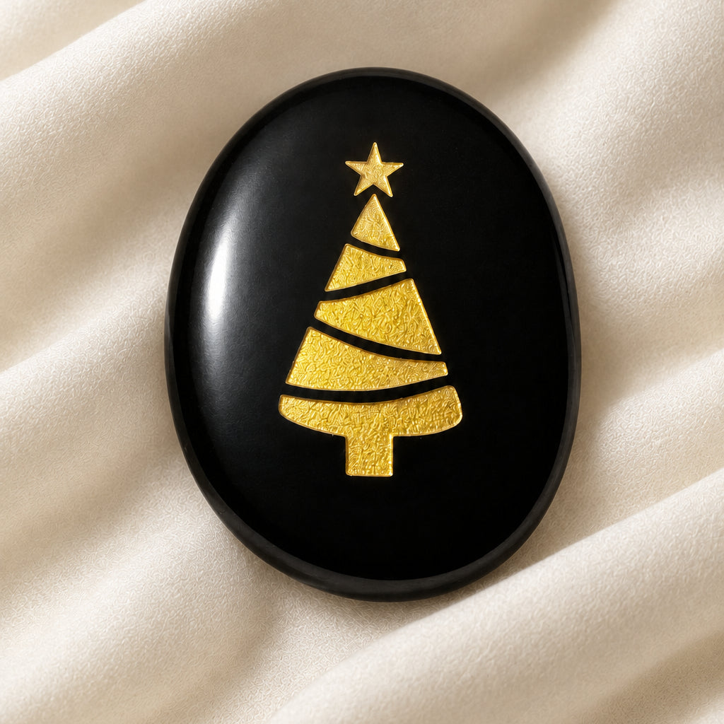 Black agatre worry stone with a christmas tree etched on the front