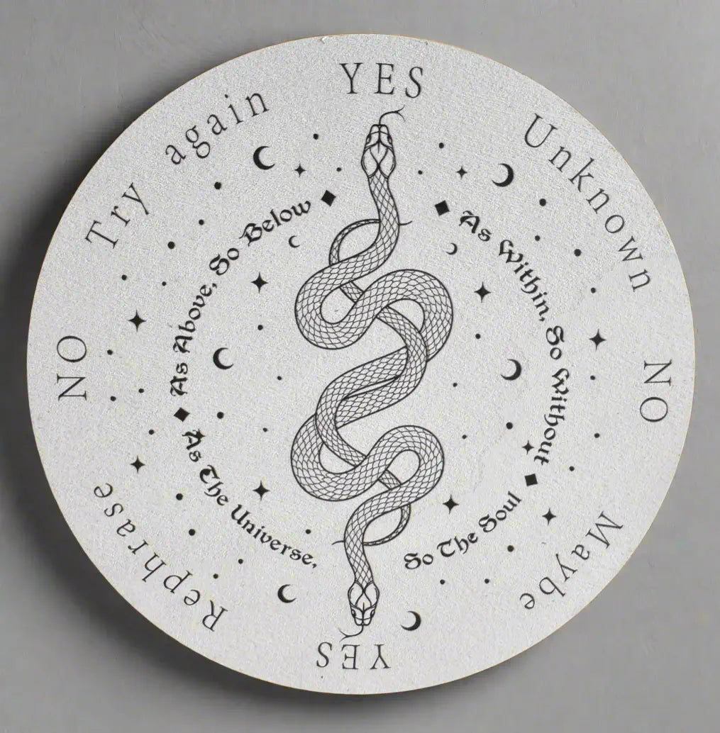 White round spirit board with black text, images of stars, moons, and a snake.