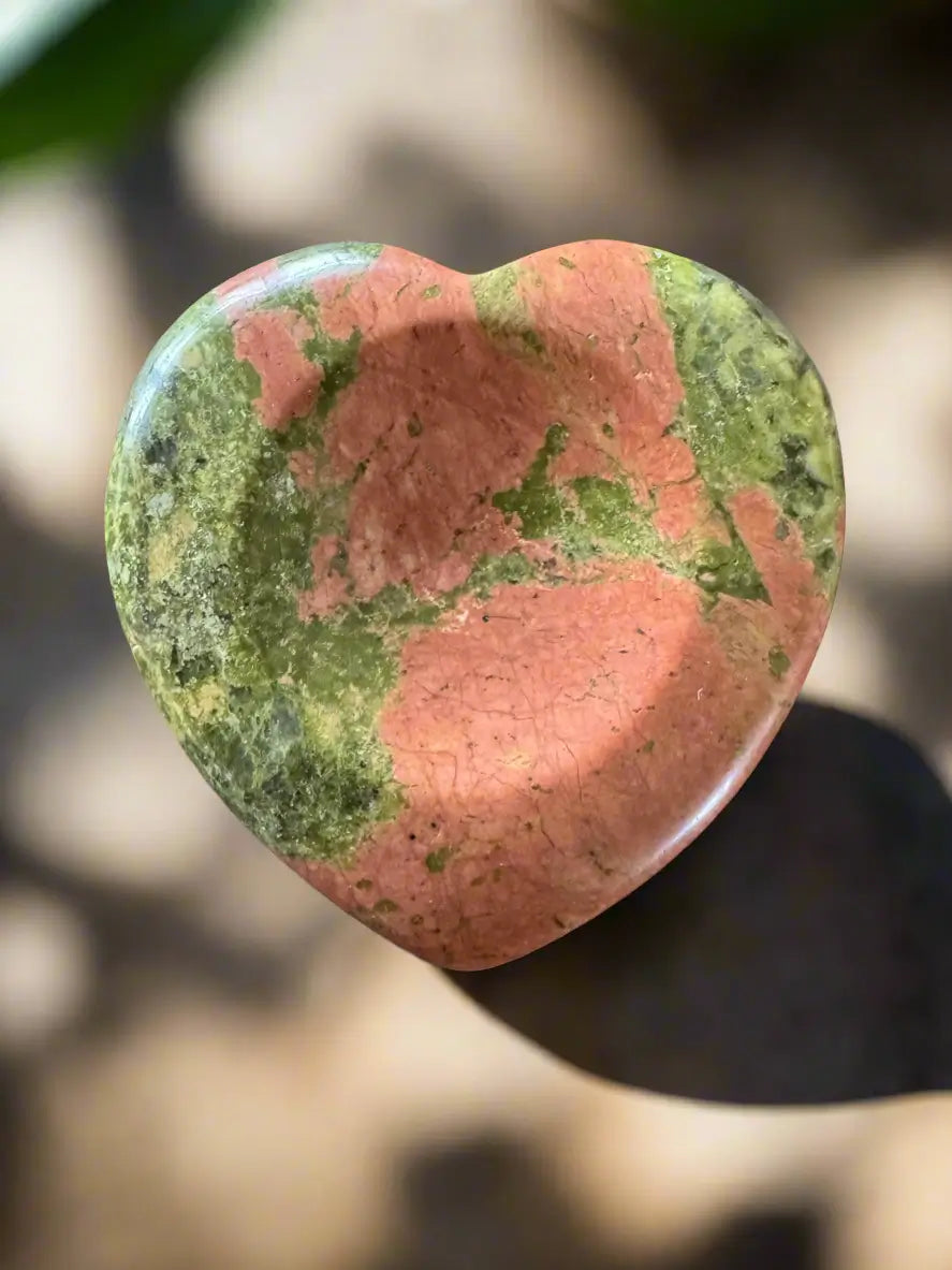 Heart-shaped unakite gemstone with red and green coloring.