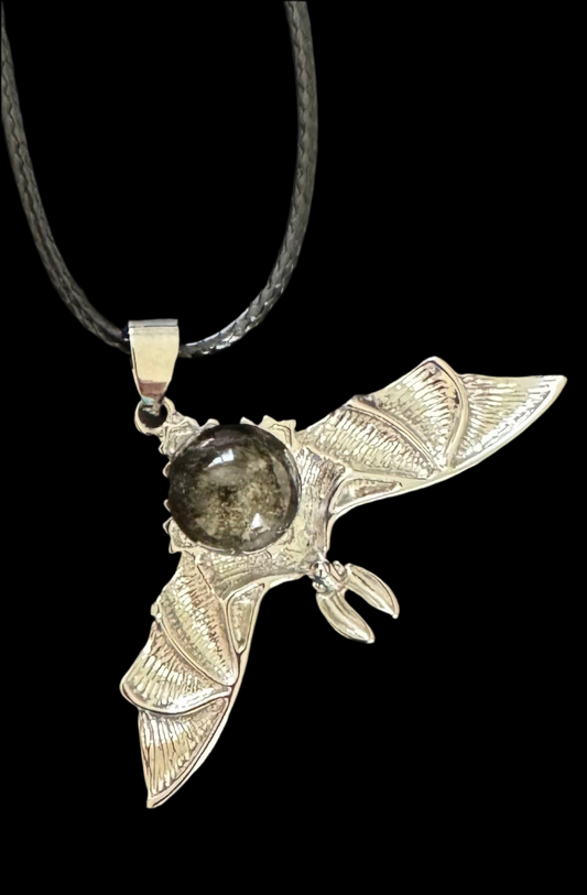 Silver bat necklace with dark gem.