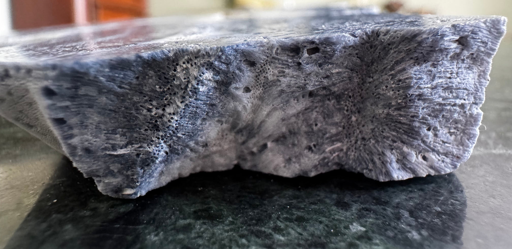 Close-up of a porous, bluish-gray stone block.