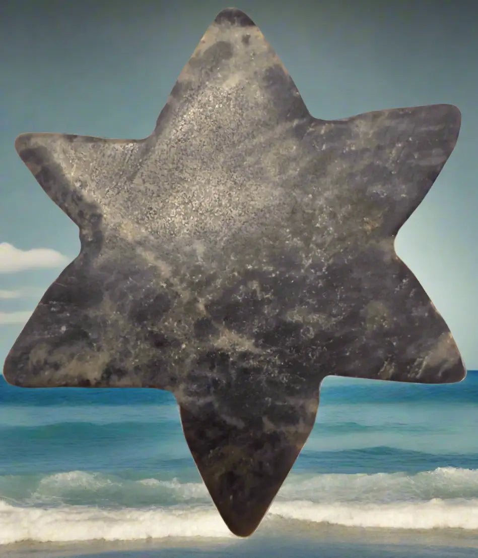 Gray stone Star of David with beach background.
