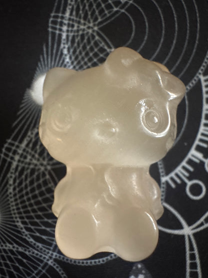 Cream-colored bear figurine on black background.