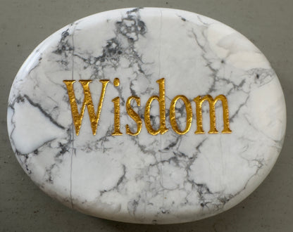 Oval, white marble stone with gold lettering: "Wisdom".
