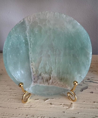 Blue-green circular fluorite plate on gold spiral stand.