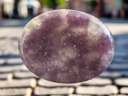 Oval-shaped, polished, purple lepidolite stone.