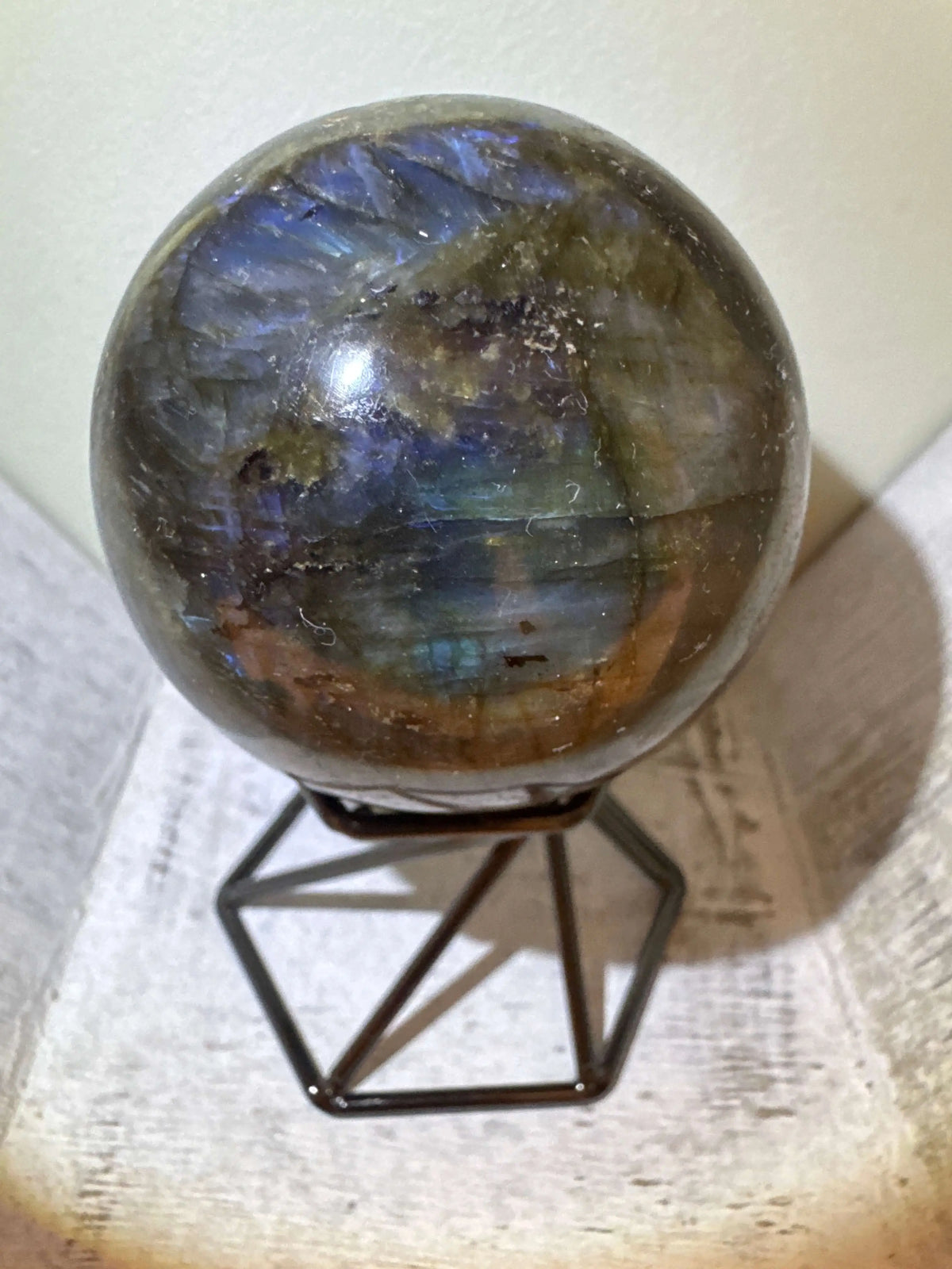 Labradorite sphere on black metal stand