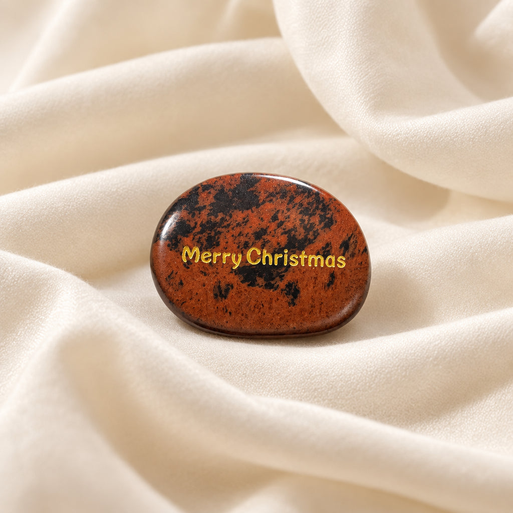 worry stone made from Mahogany Jasper carved to an oval shape and engraved on one side with Merry Christmas in a gold tone lettering