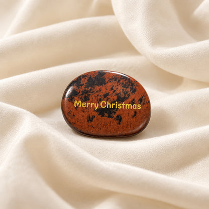 worry stone made from Mahogany Jasper carved to an oval shape and engraved on one side with Merry Christmas in a gold tone lettering