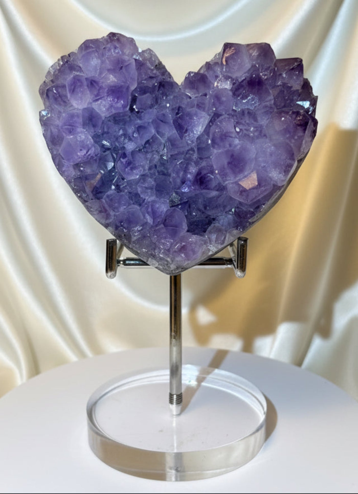 Beautiful dark purple amethyst carved heart on a premium metal and acrylic stand