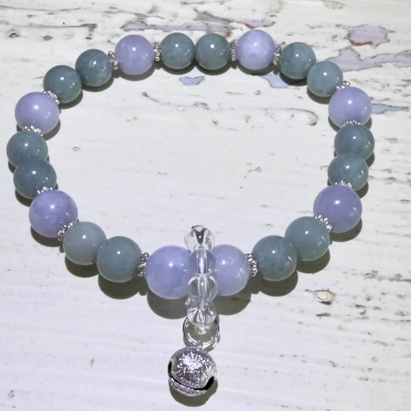 8.45mm angelite beads, 7.45mm aventurine beads, clear quartz beads and a silvery protection bell.  beautiful soft blues and greens, 