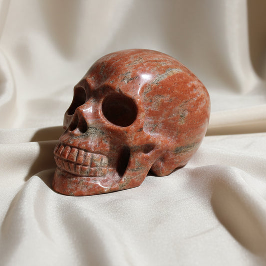 close up of brecciated jasper carved human skull copper colors, hematite inclusions, quality hand carved