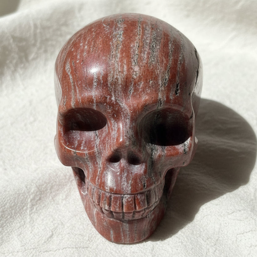 soft copper and orange colors looking down at the brecciated jasper skull with hematite and iron oxide streaks 