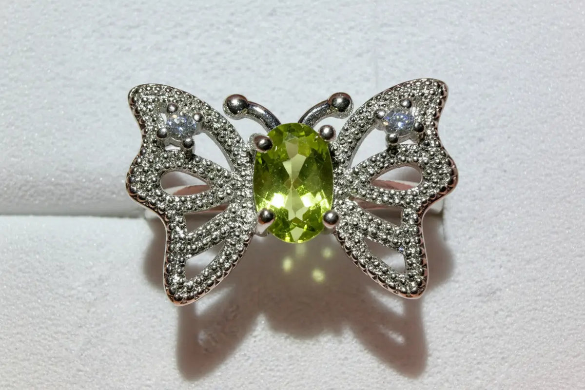 silvery butterfly ring with peridot stone and rhinestones 
