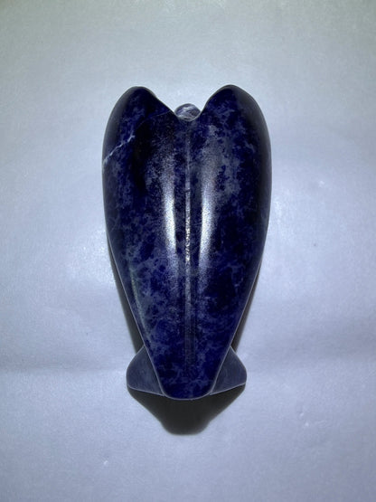 photo back of natural sodalite hand carved angel figurine resting on a white background