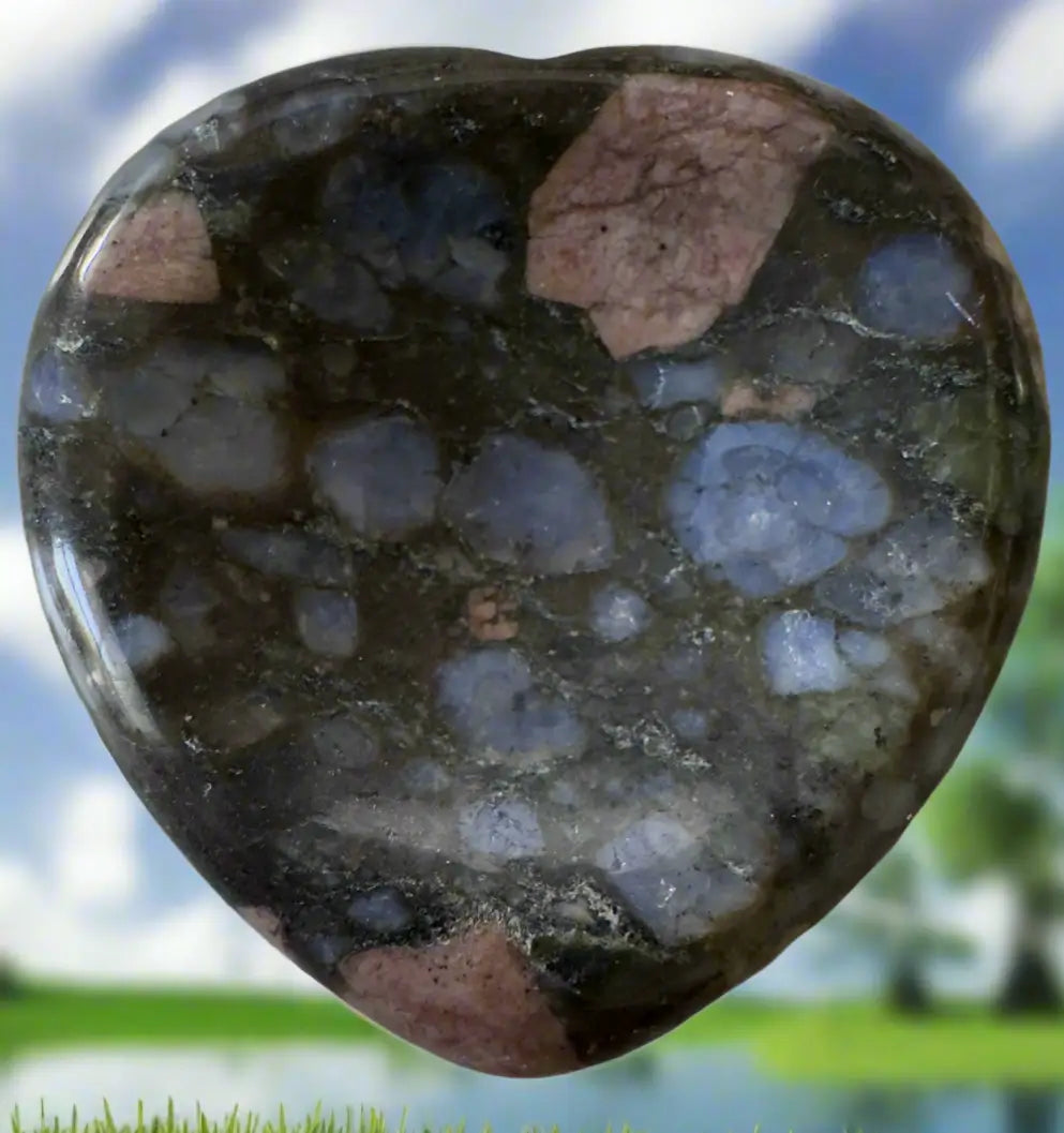 Polished heart-shaped stone with mixed colors and textures.
