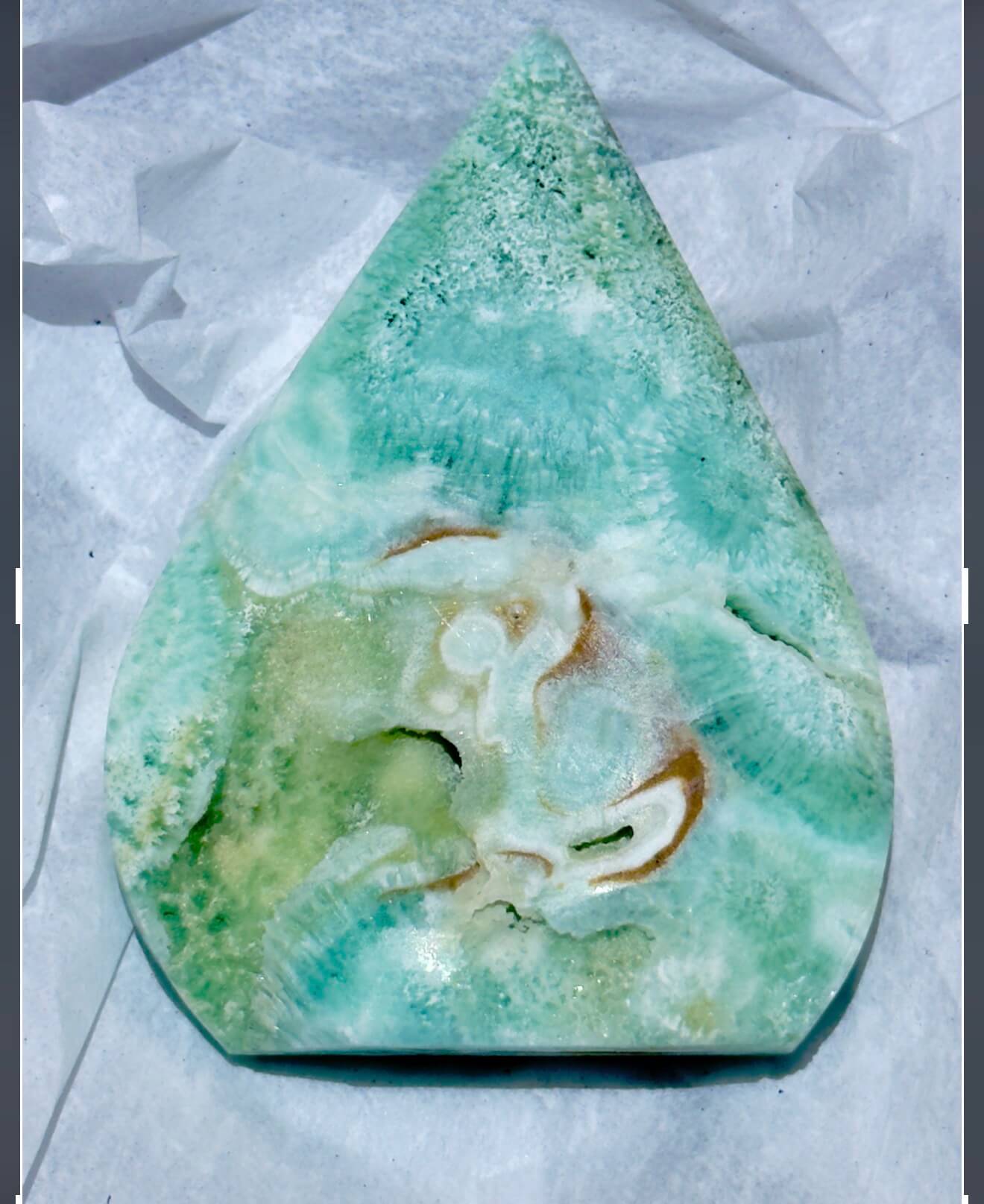 close up of caribbean calcite freeform.  soft ocean blues and greens with the creamy brown of aragonite 