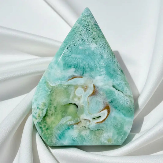 close up of caribbean calcite freeform.  soft ocean blues and greens with the creamy brown of aragonite 