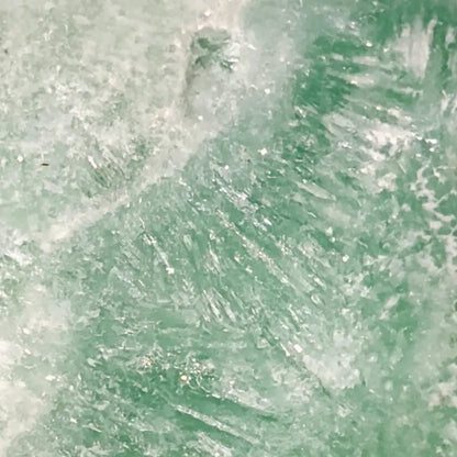 close up of a caribbean calcite freeform showing the ice like mineral inclusions  beautiful ocean blues