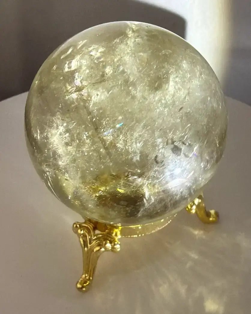 close up of citrine sphere on a gold stand 