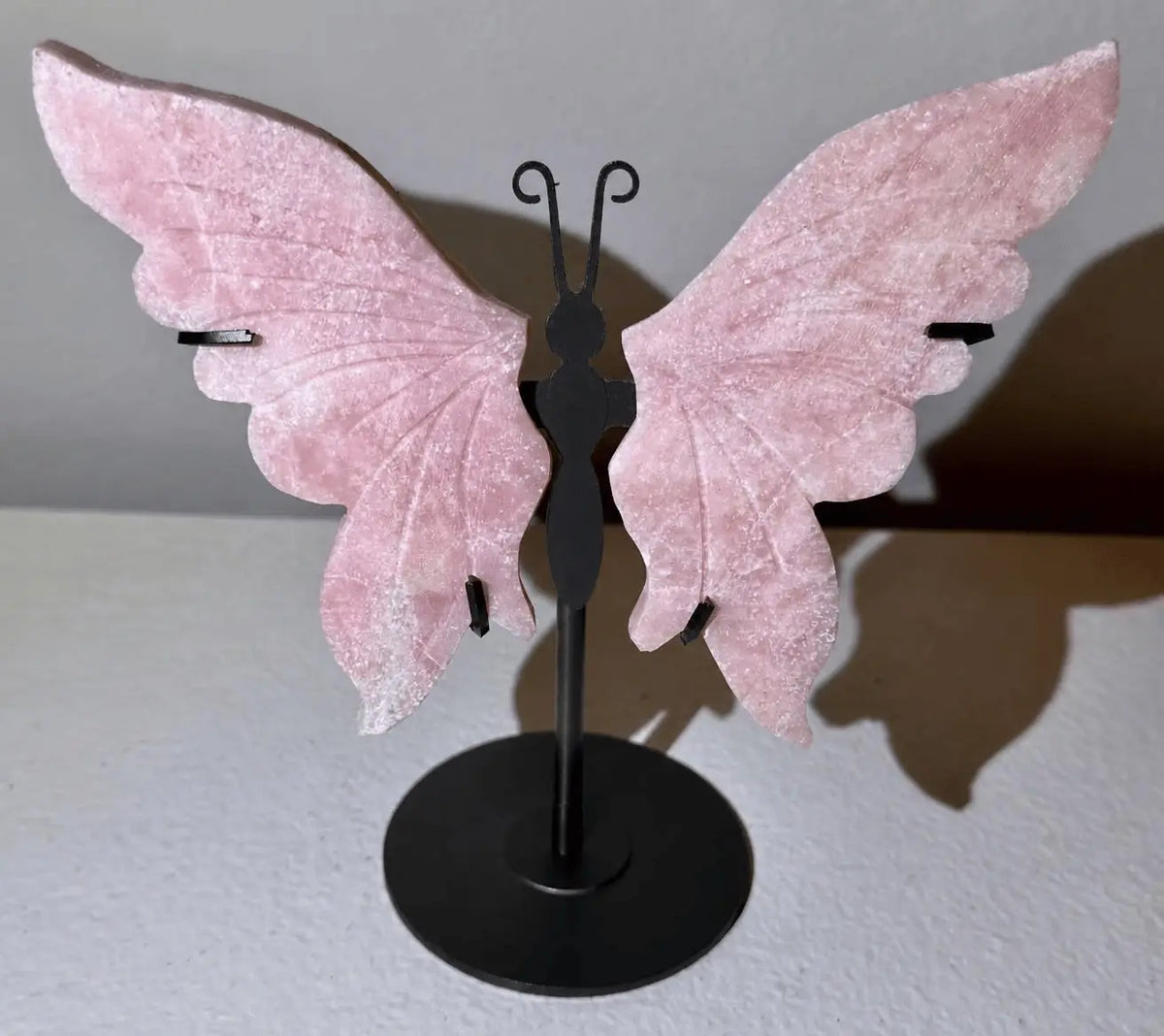 Carved with details butterfly with pink opal crystal.  Crystal wings on a display stand (metal)