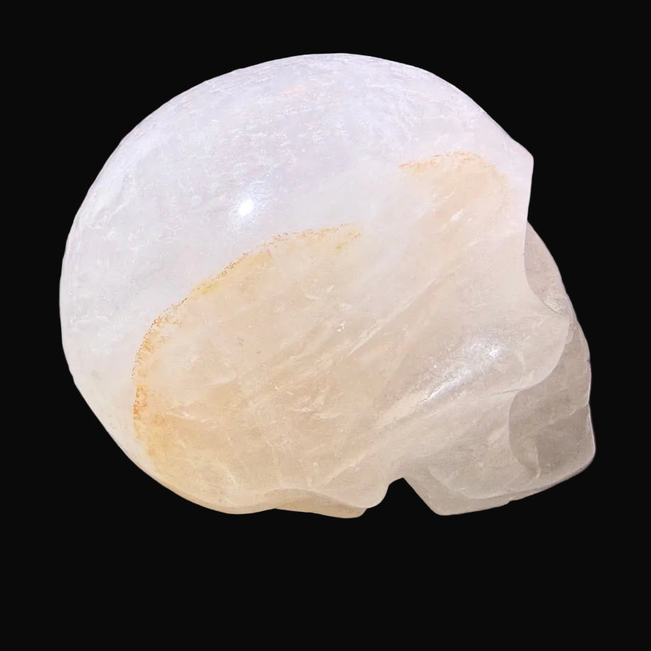 Side view of hand carved clear quartz skull showing golden healer inclusion 