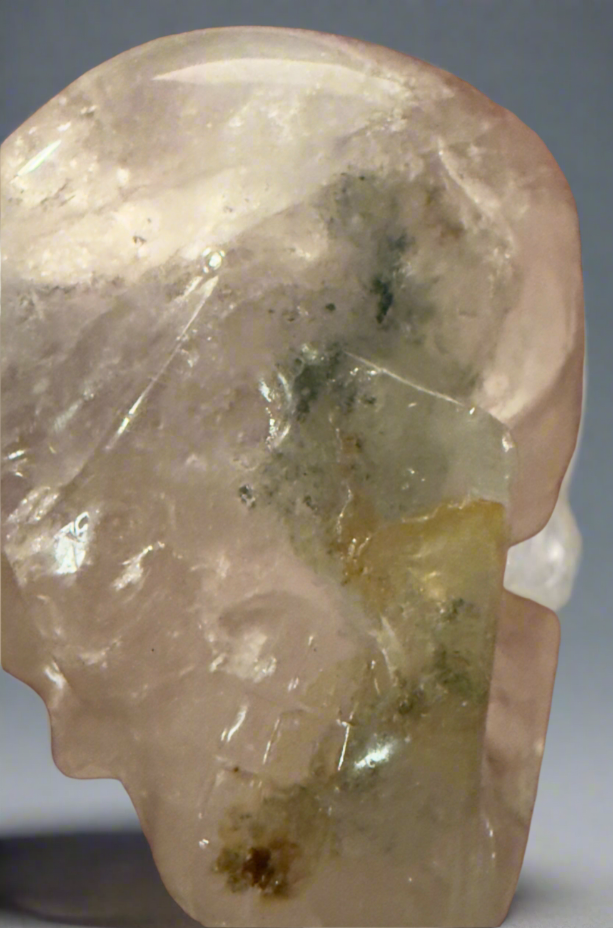 Close up of clear quartz hand carved skull with moss agate inclusions 