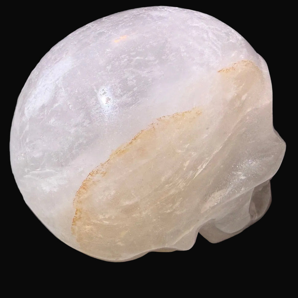 Side view of clear quartz skull with golden healer inclusion 