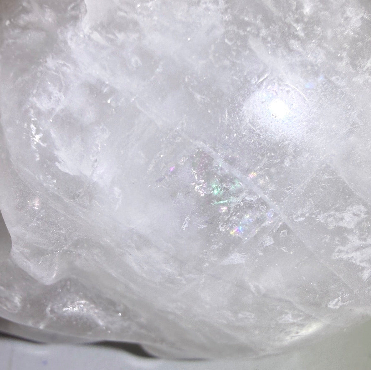 close up clear quartz hand carved skull with rainbows 