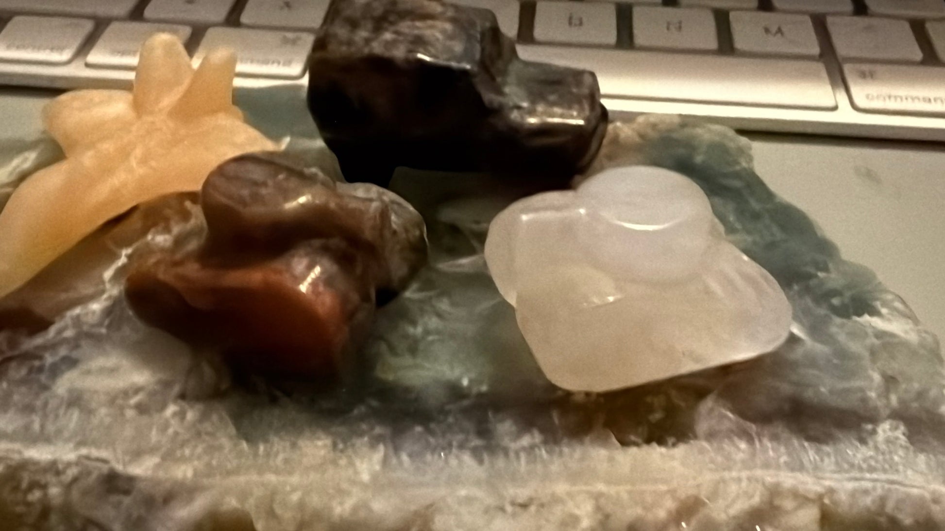 photo of four hand carved pieces, two tanks, clear quartz with citrine inclusion, brecciated jasper, yellow calcite jet, and yooperlite jeep truck  