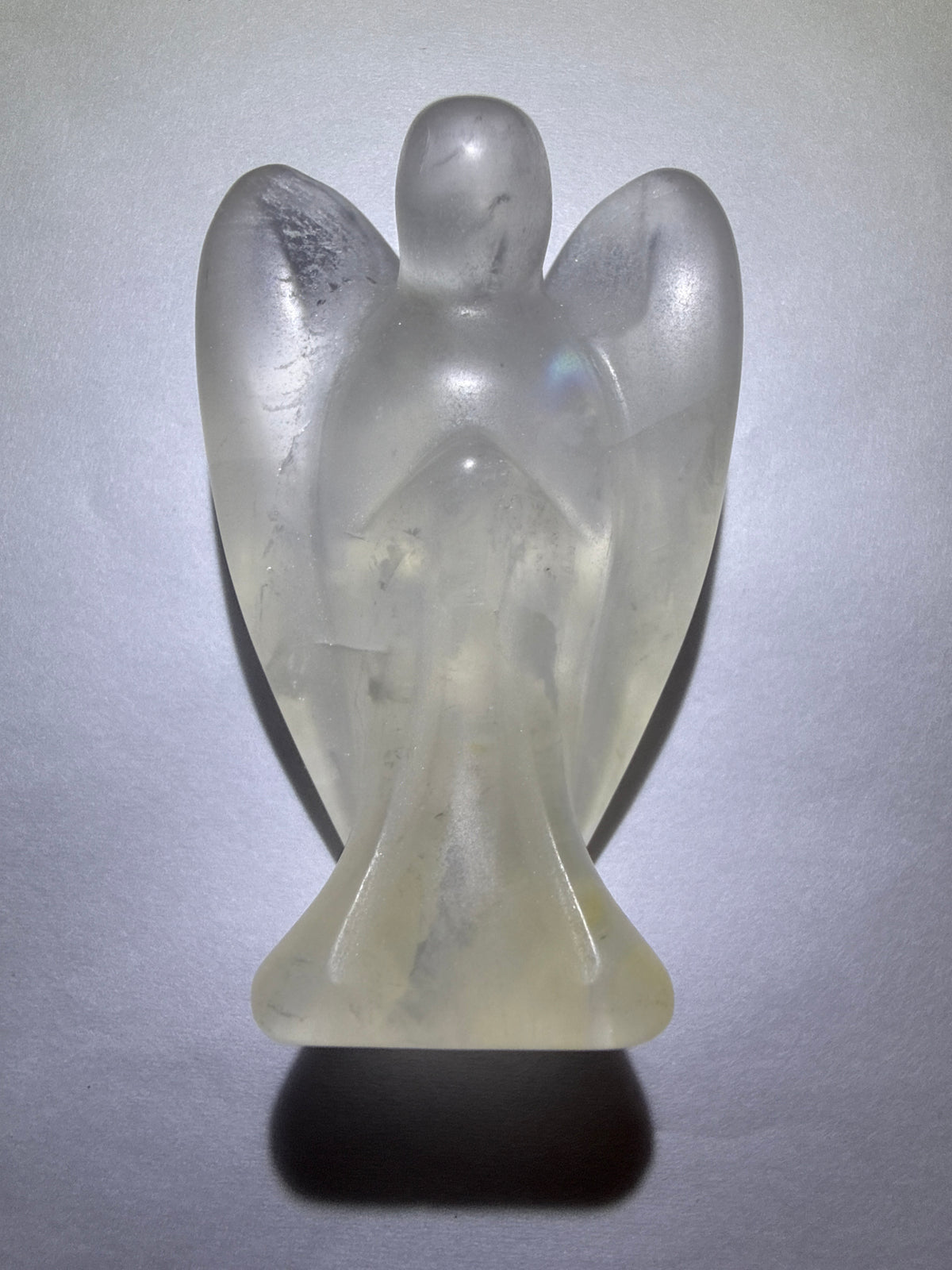 photo of clear quartz hand carved angel with wings. Inclusions Iron Oxide and rutile trapped inside the quartz 