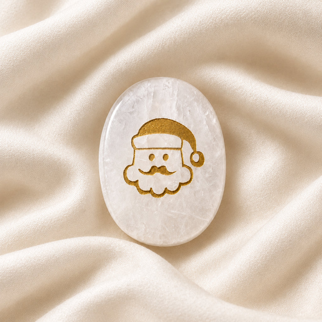 worry stone carved from clear quartz mineral, silicon dioxide with gold tone etching of a santa face on one side