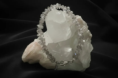 Herkimer Diamond Genuine Herkimer crystal bracelet with lobster claw clasp on a white rock with a black background