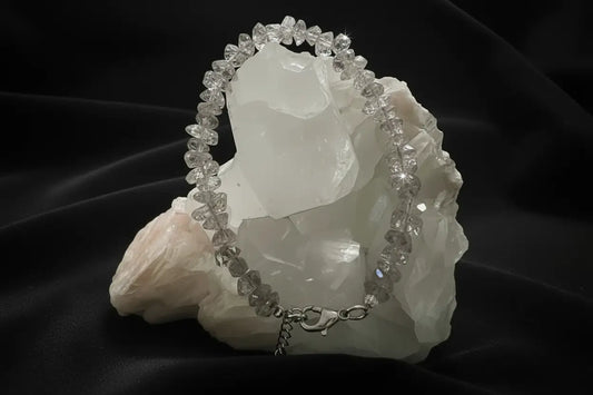 Herkimer Diamond Genuine Herkimer crystal bracelet with lobster claw clasp on a white rock with a black background