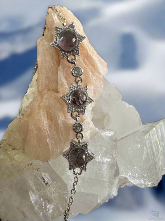 Silver bracelet with star-shaped gems on a rough mineral backdrop.