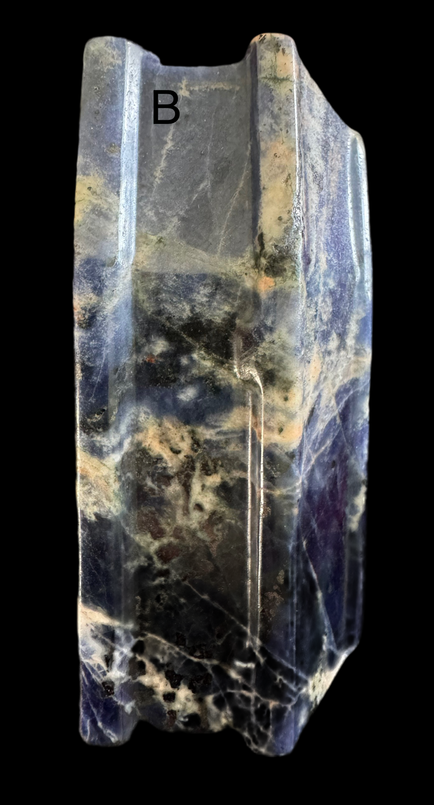 Polished sodalite with white veining and letter "B."