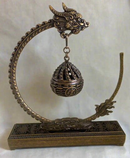 Brass dragon incense holder with spherical lattice burner front view