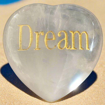 Heart-shaped clear stone with gold "Dream" inscription.