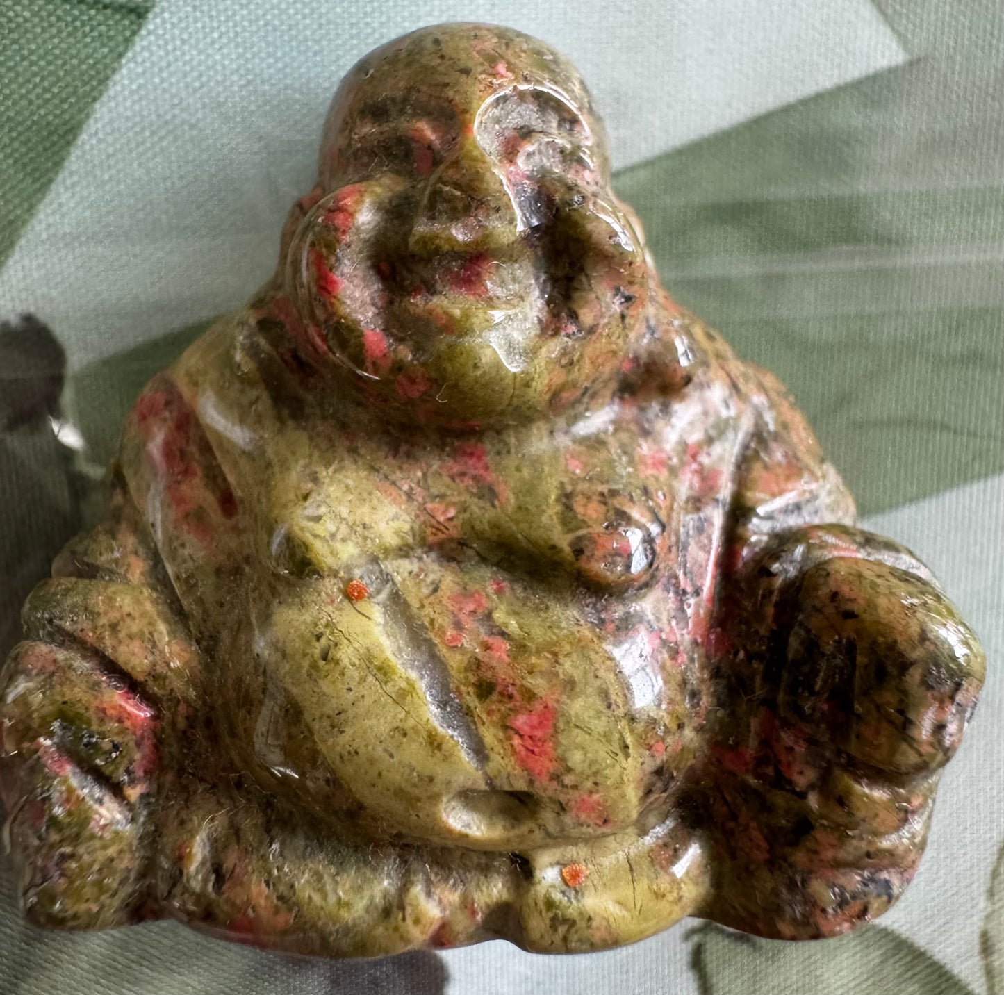 Green and red stone Buddha figurine.
