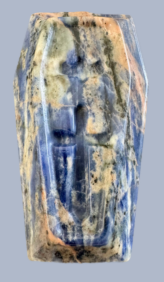 Blue, tan, and grey stone artifact with carved cross.

