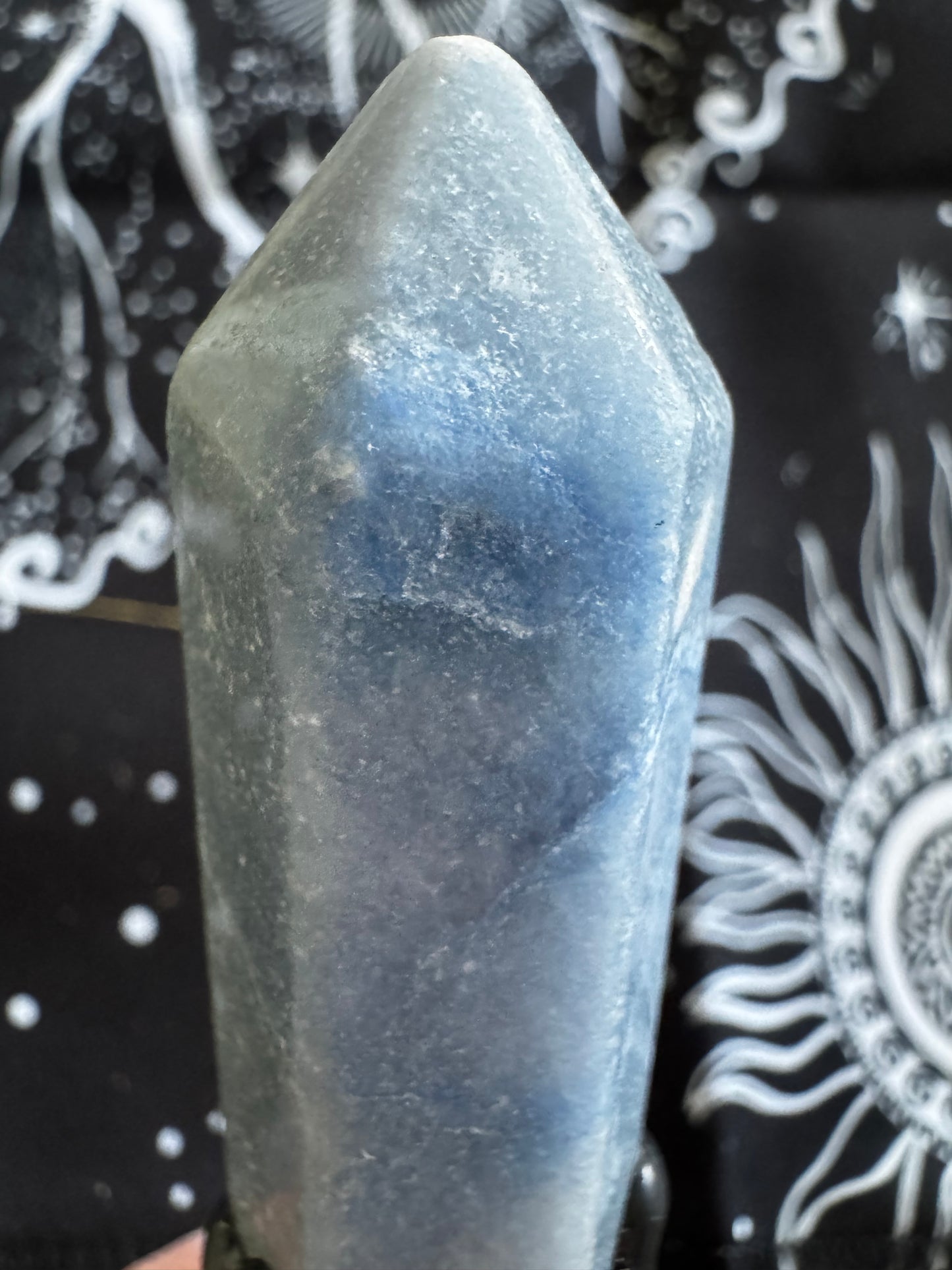 Blue crystal point with a blurred background.
